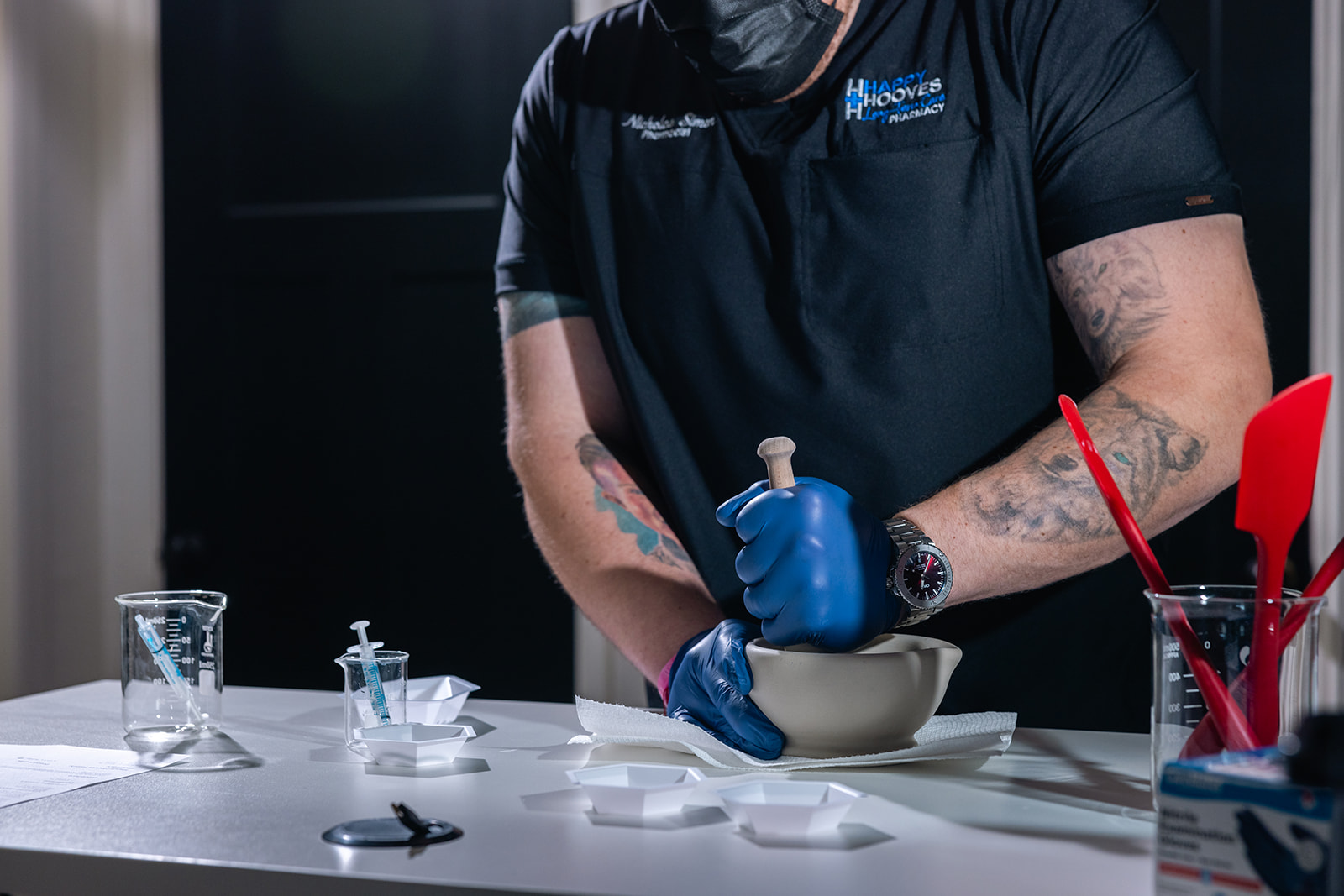 Pharmacist at Happy Hooves Family Pharmacy using mortar and pestle to hand-compound medication in clinical lab setting"