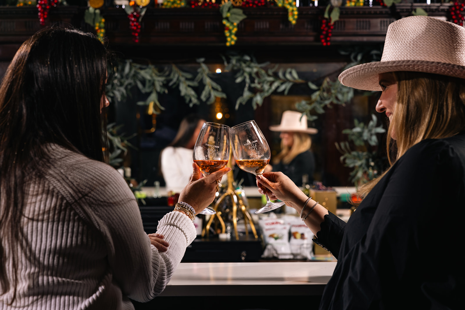 Two women clinking glasses of rosé at Turtle Creek Vineyard tasting room in downtown Kerrville during a wine experience